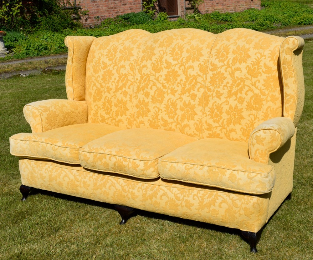 An early 20th-century Georgian style three-seater settee upholstered in yellow floral damask fabric with a serpentine crest back and scrolled arms. View XIII
