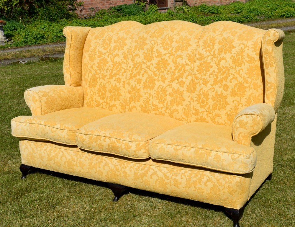 An early 20th-century Georgian style three-seater settee upholstered in yellow floral damask fabric with a serpentine crest back and scrolled arms. View XIV