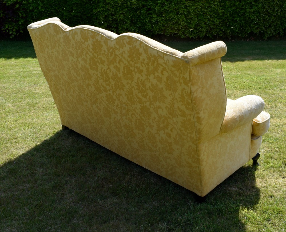 An early 20th-century Georgian style three-seater settee upholstered in yellow floral damask fabric with a serpentine crest back and scrolled arms. View XVI