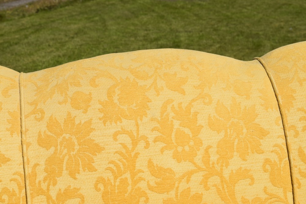 An early 20th-century Georgian style three-seater settee upholstered in yellow floral damask fabric with a serpentine crest back and scrolled arms. View XVII