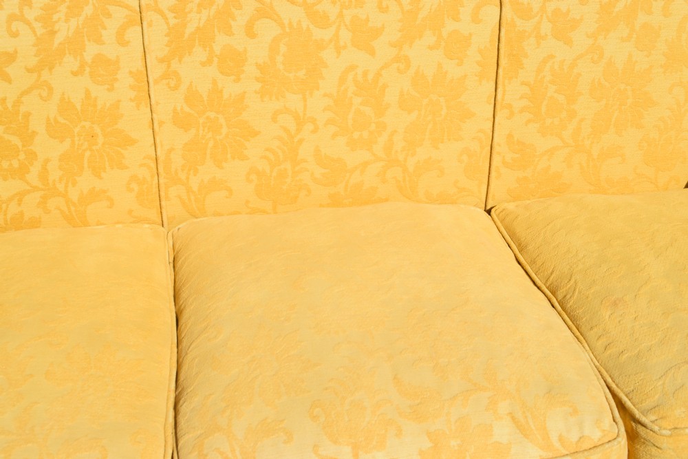 An early 20th-century Georgian style three-seater settee upholstered in yellow floral damask fabric with a serpentine crest back and scrolled arms. View XVIII