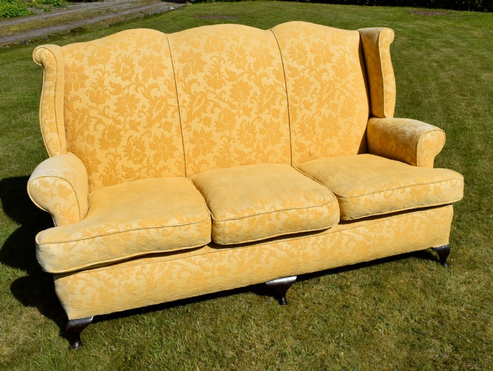 An early 20th-century Georgian style three-seater settee upholstered in yellow floral damask fabric with a serpentine crest back and scrolled arms. View XIX