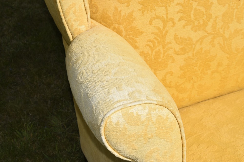 An early 20th-century Georgian style three-seater settee upholstered in yellow floral damask fabric with a serpentine crest back and scrolled arms. View XXII