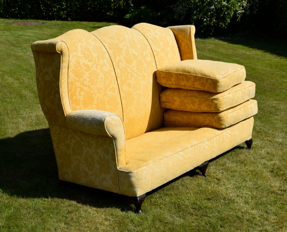 An early 20th-century Georgian style three-seater settee upholstered in yellow floral damask fabric with a serpentine crest back and scrolled arms. View XXIV