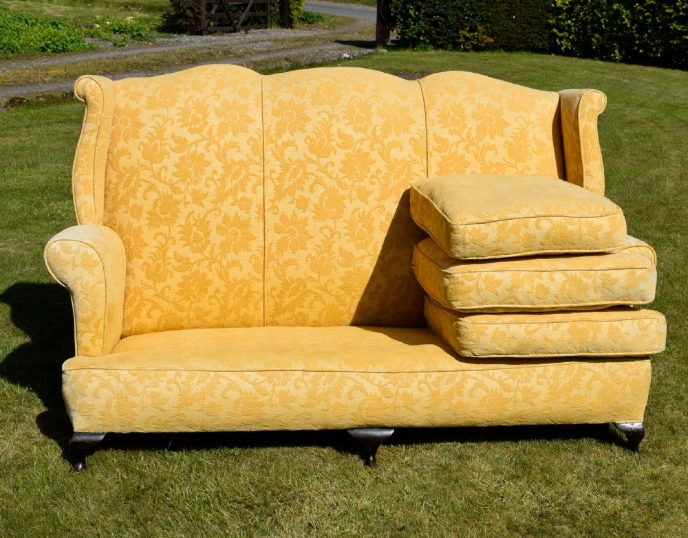 An early 20th-century Georgian style three-seater settee upholstered in yellow floral damask fabric with a serpentine crest back and scrolled arms. View XXV