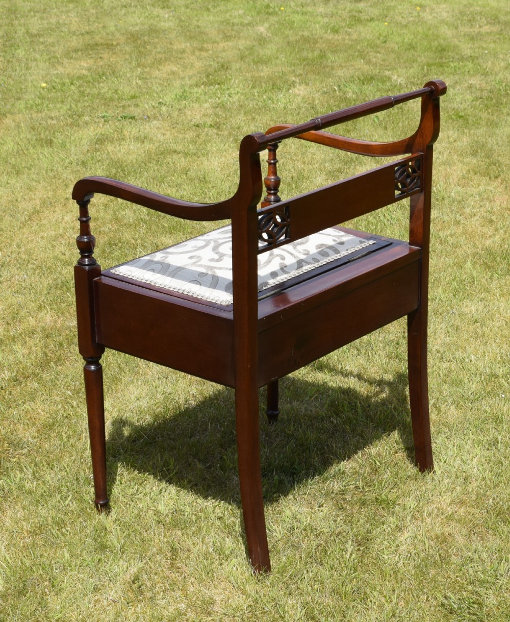 An Edwardian mahogany piano stool featuring marquetry inlay on the backrest, turned side handles, cream patterned upholstered lift-top seat, and tapered legs. View VIII