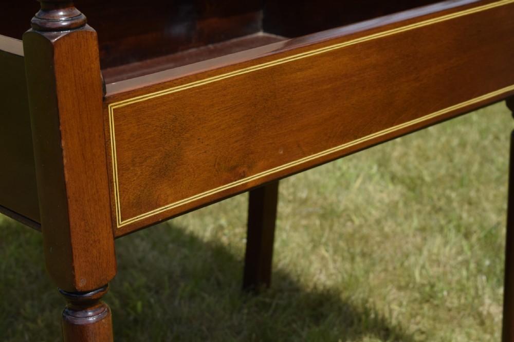 An Edwardian mahogany piano stool featuring marquetry inlay on the backrest, turned side handles, cream patterned upholstered lift-top seat, and tapered legs. View X