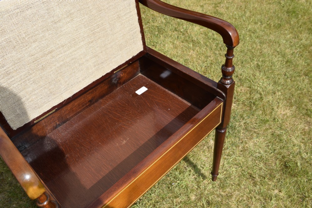 An Edwardian mahogany piano stool featuring marquetry inlay on the backrest, turned side handles, cream patterned upholstered lift-top seat, and tapered legs. View XVIII