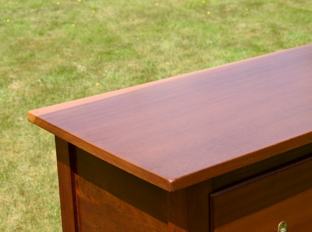 An antique mahogany dresser base featuring two drawers with brass handles, a scalloped apron, and front cabriole legs ending in pad feet. View VII