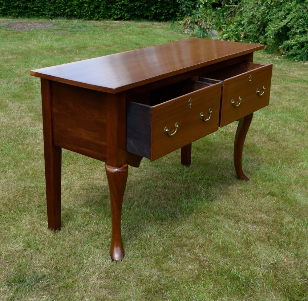 An antique mahogany dresser base featuring two drawers with brass handles, a scalloped apron, and front cabriole legs ending in pad feet. View IX
