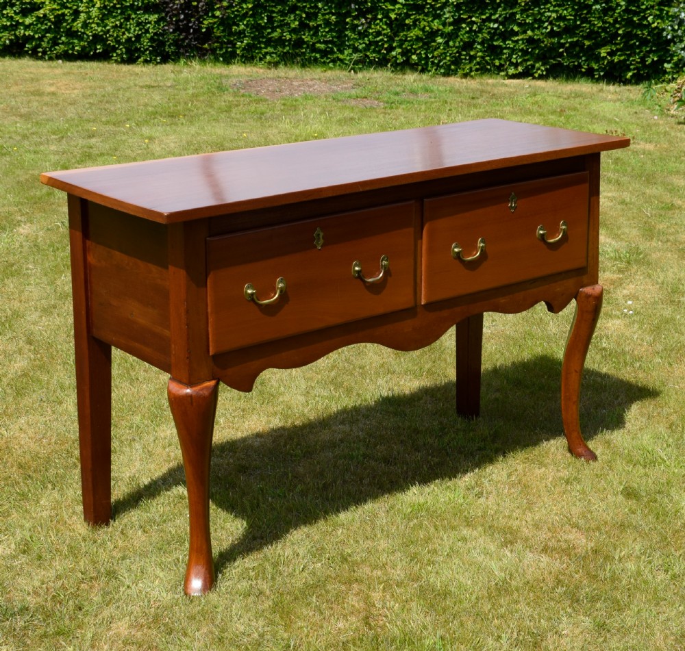 An antique mahogany dresser base featuring two drawers with brass handles, a scalloped apron, and front cabriole legs ending in pad feet. View XIII