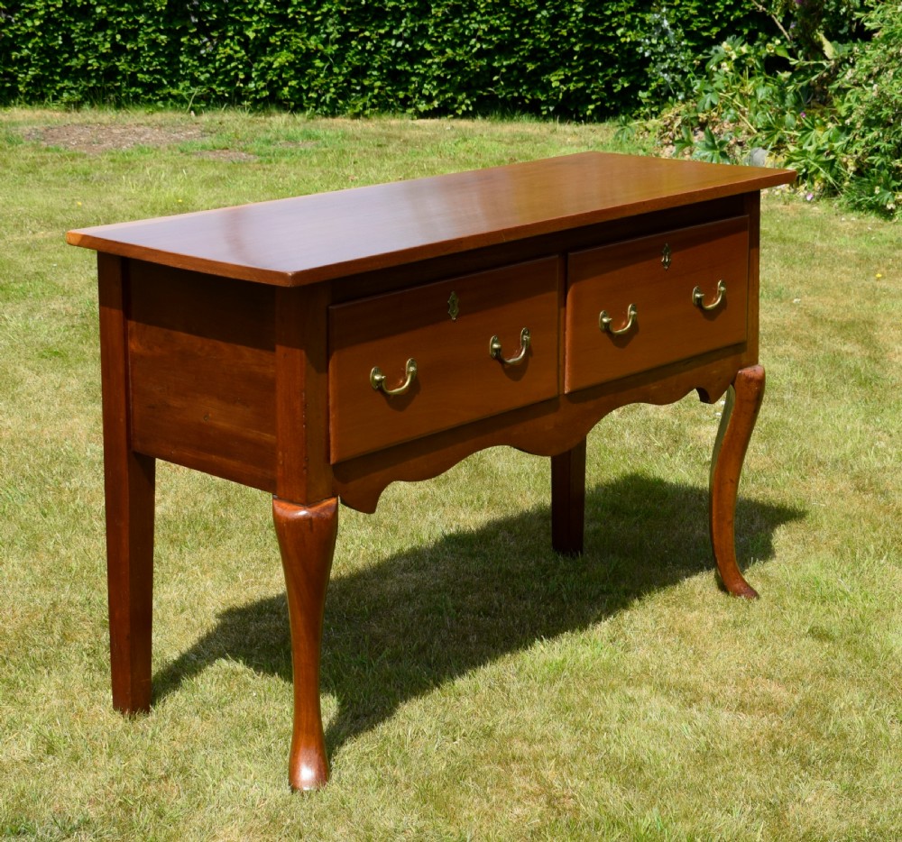An antique mahogany dresser base featuring two drawers with brass handles, a scalloped apron, and front cabriole legs ending in pad feet. View XIV