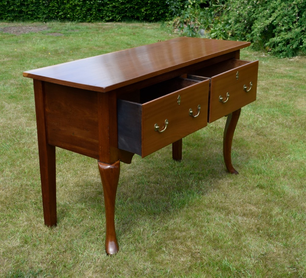 An antique mahogany dresser base featuring two drawers with brass handles, a scalloped apron, and front cabriole legs ending in pad feet. View XVII