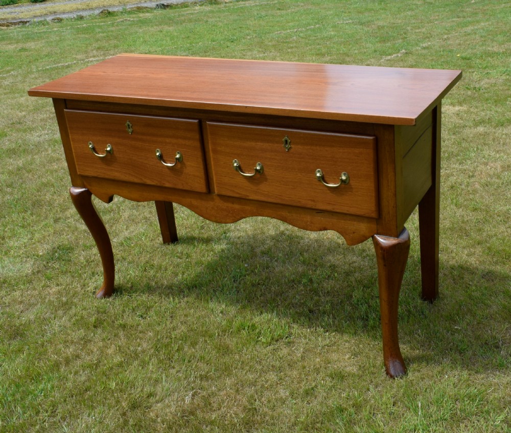 An antique mahogany dresser base featuring two drawers with brass handles, a scalloped apron, and front cabriole legs ending in pad feet. View XXII