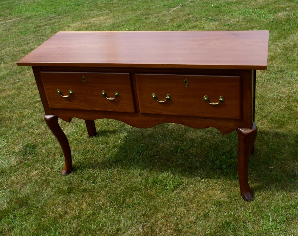 An antique mahogany dresser base featuring two drawers with brass handles, a scalloped apron, and front cabriole legs ending in pad feet. View XXIII