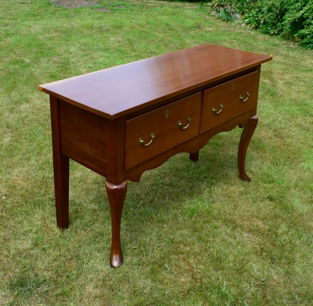 An antique mahogany dresser base featuring two drawers with brass handles, a scalloped apron, and front cabriole legs ending in pad feet. View XXIV