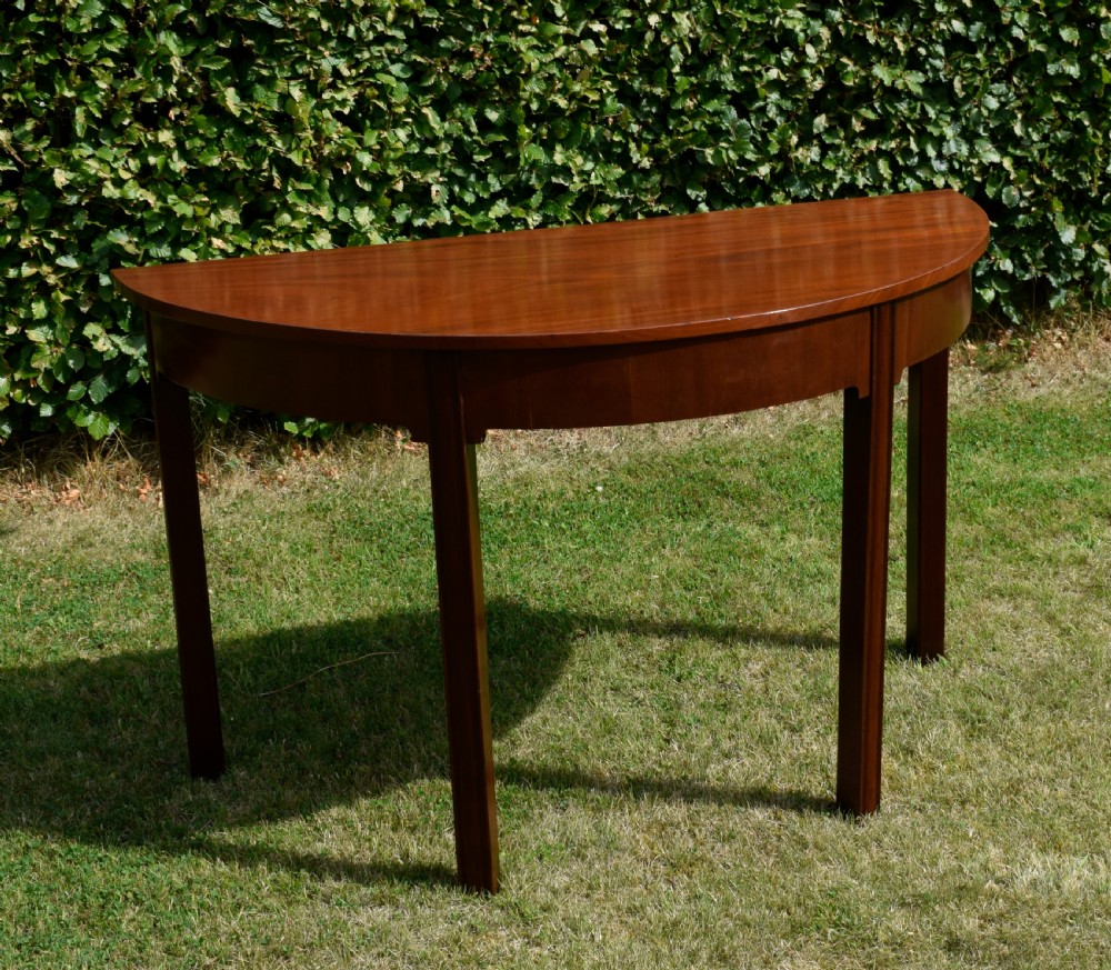 A Georgian mahogany demi-lune console table featuring a semi-circular top and four tapered legs. View III