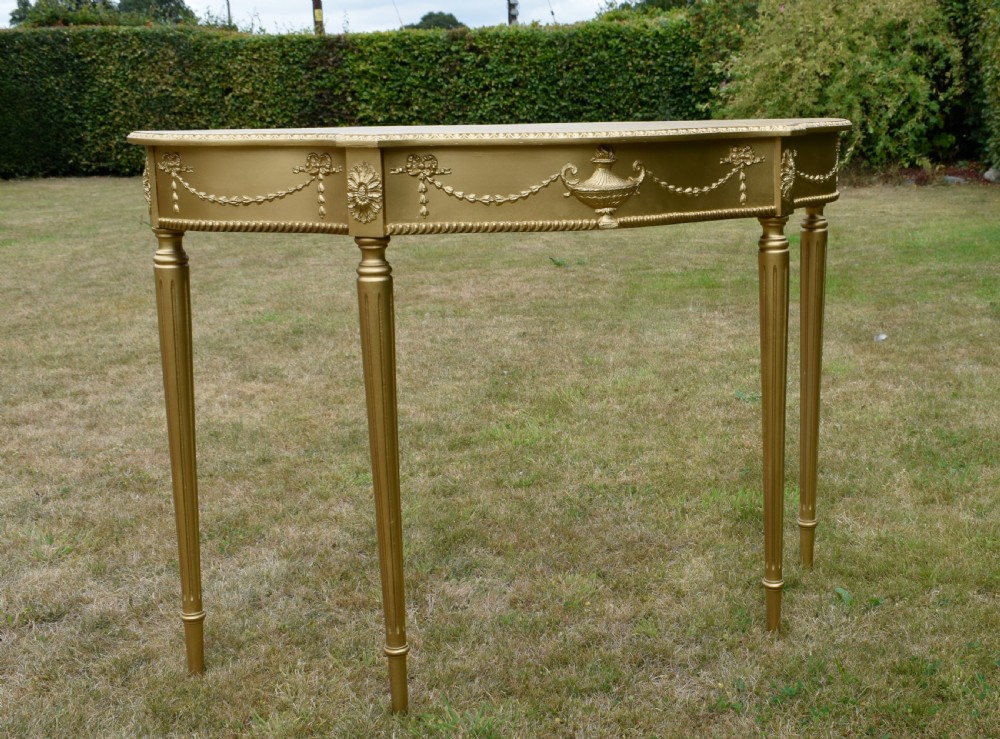A gold gilded early twentieth-century console table featuring carved swags, a central urn motif, and fluted tapered legs. View III