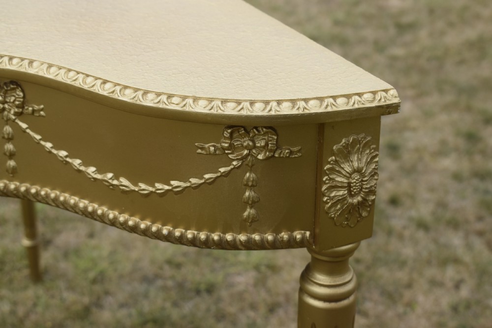 A gold gilded early twentieth-century console table featuring carved swags, a central urn motif, and fluted tapered legs. View XVIII