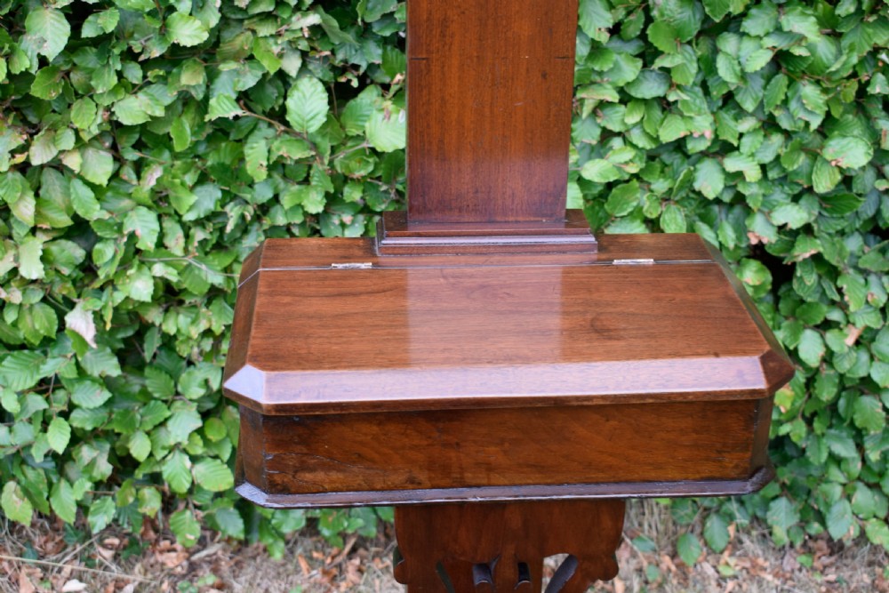 A Victorian walnut hall stand featuring carved fretwork branches, brass coat hooks, a central circular mirror, a glove box, and a lower drip tray base. View VII
