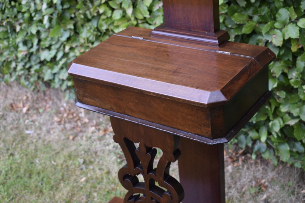 A Victorian walnut hall stand featuring carved fretwork branches, brass coat hooks, a central circular mirror, a glove box, and a lower drip tray base. View XII