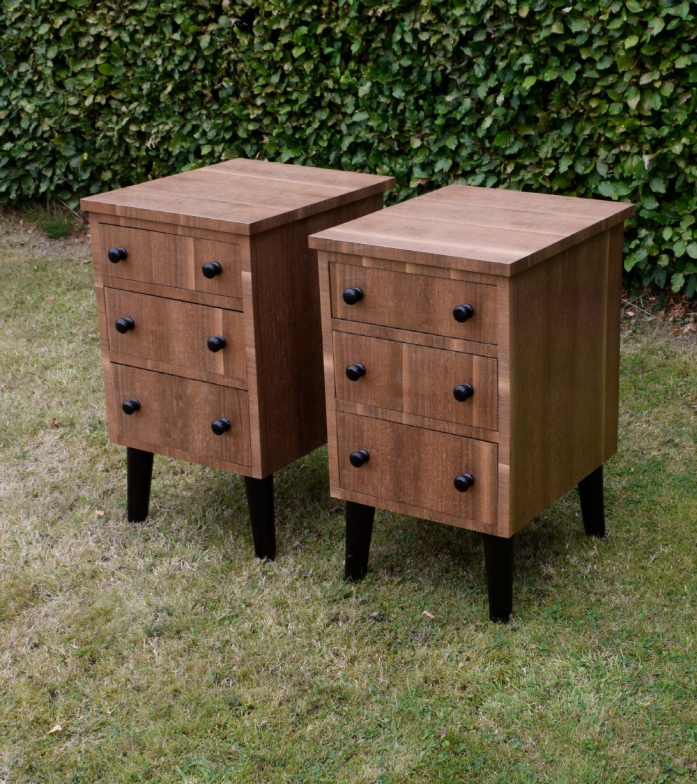 A matching pair of three-drawer walnut bedside chests featuring dark turned knobs and ebonised tapered legs. View III