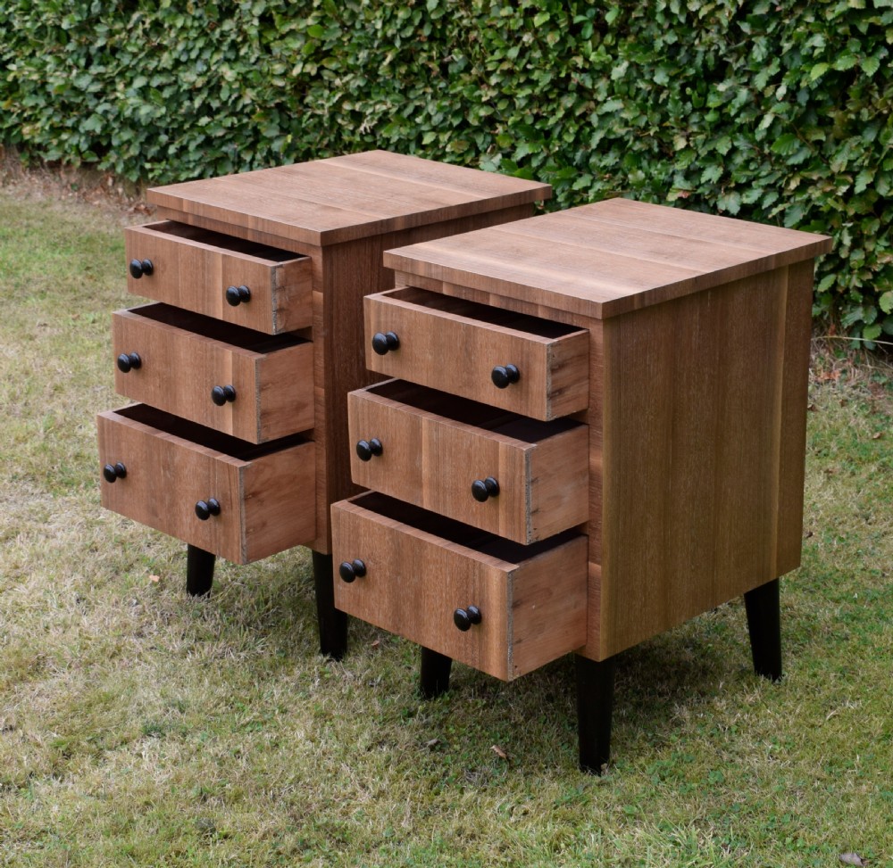 A matching pair of three-drawer walnut bedside chests featuring dark turned knobs and ebonised tapered legs. View VII