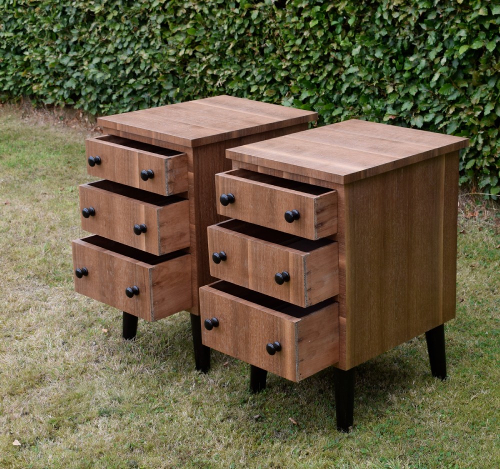 A matching pair of three-drawer walnut bedside chests featuring dark turned knobs and ebonised tapered legs. View VIII