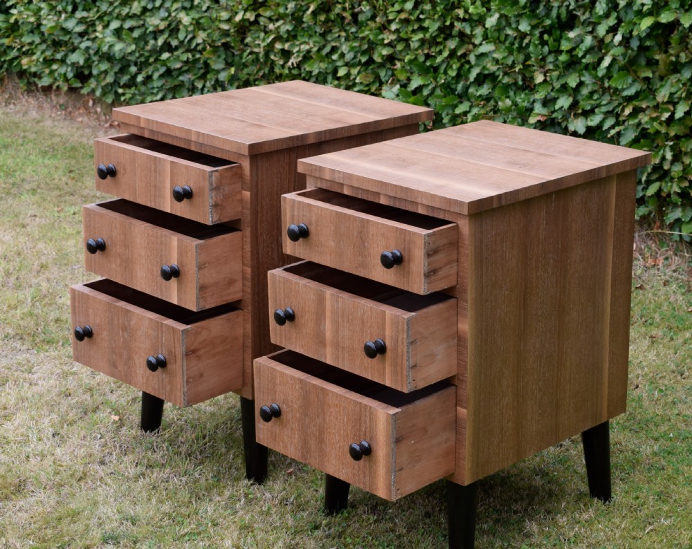 A matching pair of three-drawer walnut bedside chests featuring dark turned knobs and ebonised tapered legs. View IX