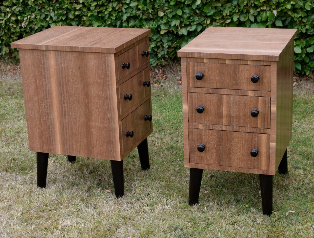 A matching pair of three-drawer walnut bedside chests featuring dark turned knobs and ebonised tapered legs. View XVI