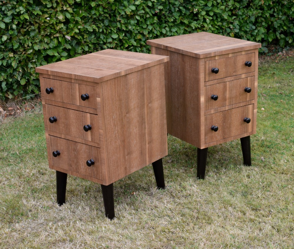 A matching pair of three-drawer walnut bedside chests featuring dark turned knobs and ebonised tapered legs. View XVII