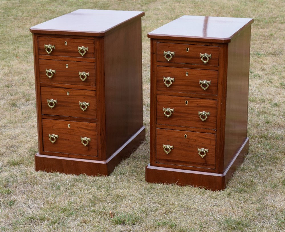 A pair of Victorian mahogany four-drawer bedside chests featuring brass ring handles, escutcheons, and plinth bases. View V