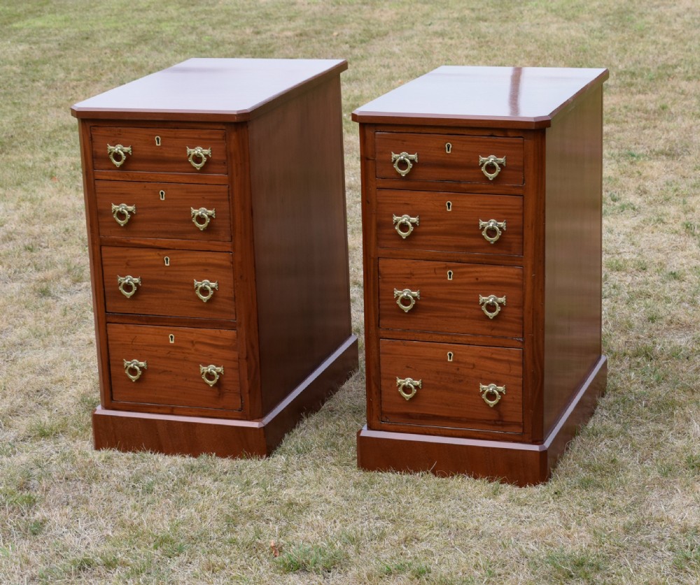 A pair of Victorian mahogany four-drawer bedside chests featuring brass ring handles, escutcheons, and plinth bases. View VI