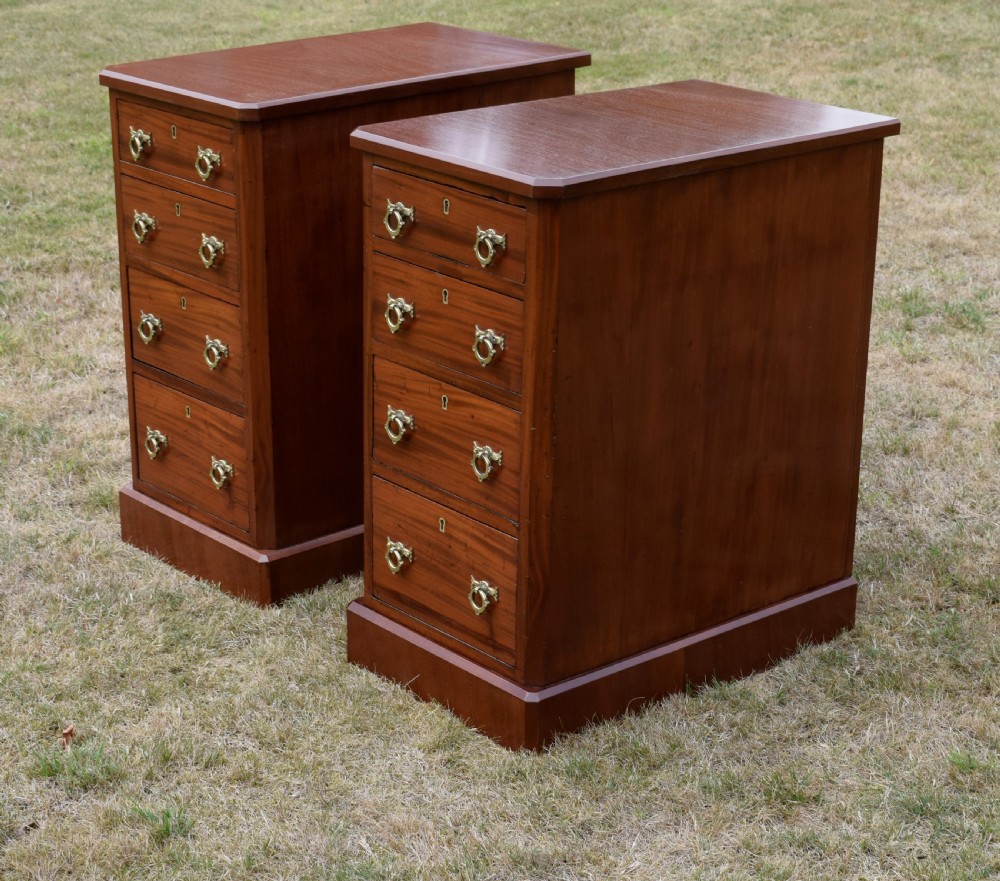 A pair of Victorian mahogany four-drawer bedside chests featuring brass ring handles, escutcheons, and plinth bases. View X