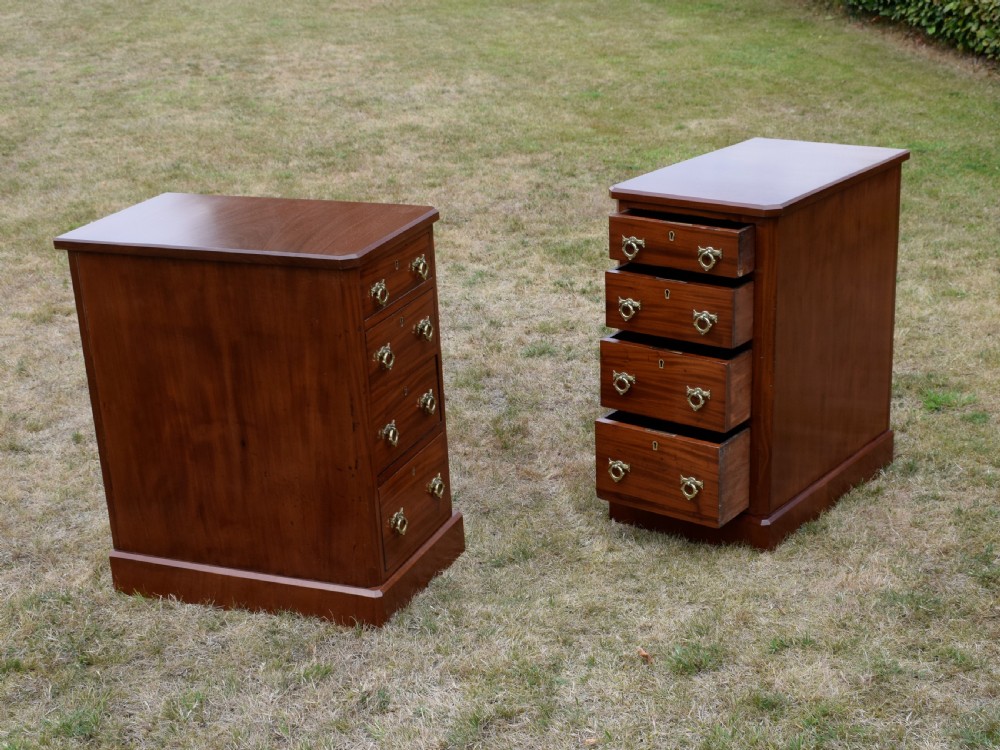 A pair of Victorian mahogany four-drawer bedside chests featuring brass ring handles, escutcheons, and plinth bases. View XV
