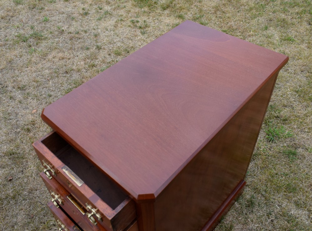 A pair of Victorian mahogany four-drawer bedside chests featuring brass ring handles, escutcheons, and plinth bases. View XVI