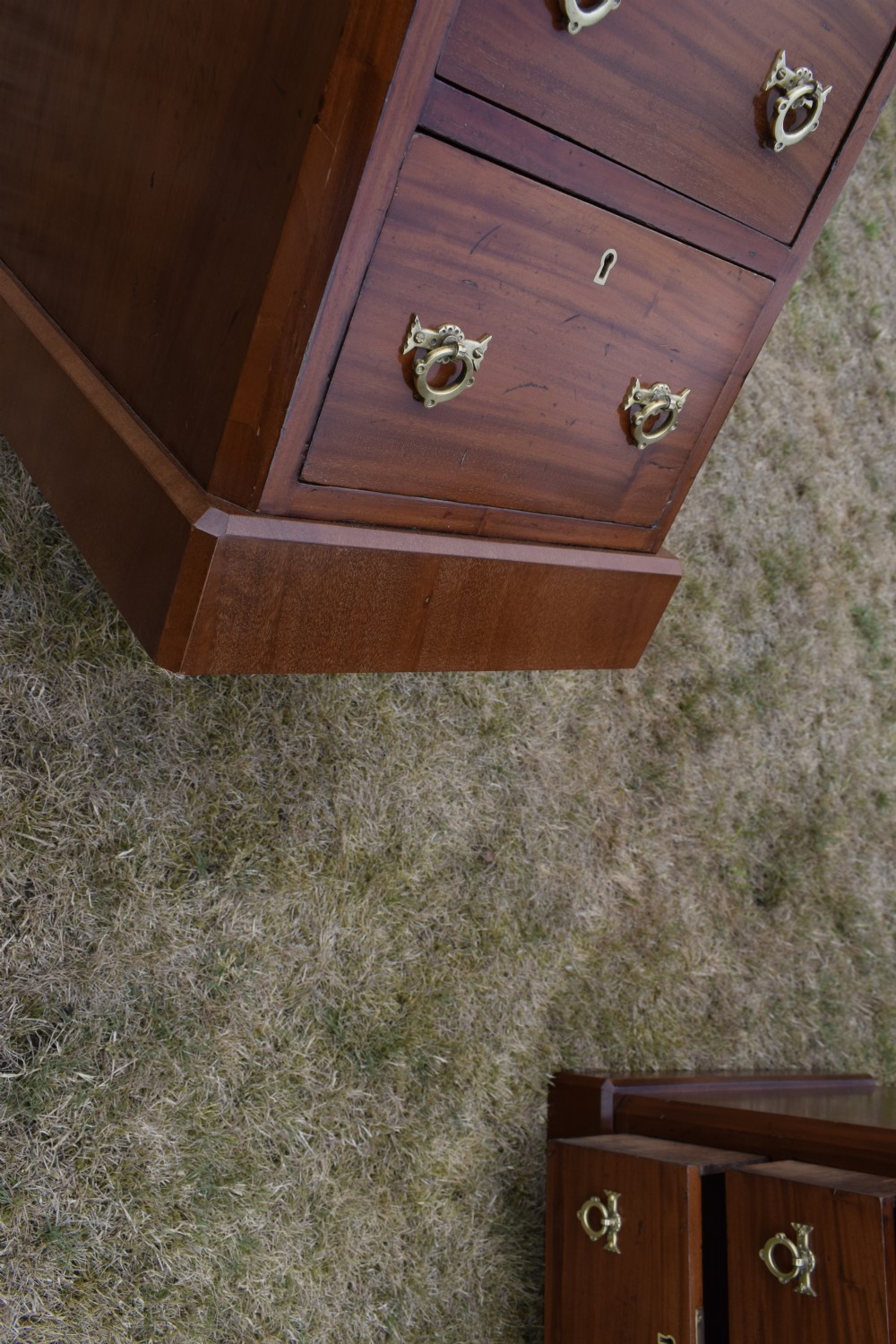 A pair of Victorian mahogany four-drawer bedside chests featuring brass ring handles, escutcheons, and plinth bases. View XVII