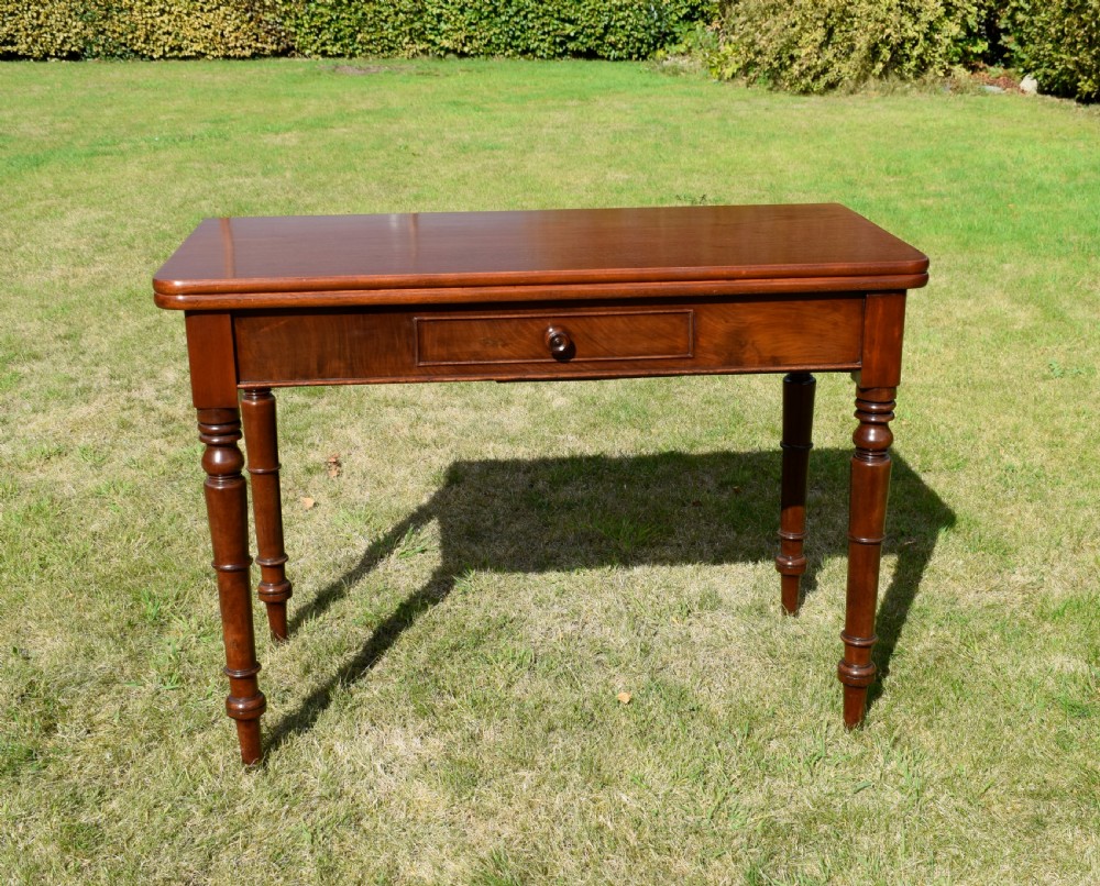 A William IV polished mahogany fold-over games table with turned legs and a single central drawer with a wooden knob. View III