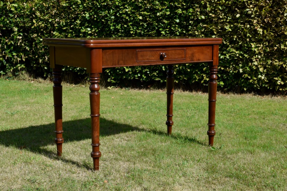A William IV polished mahogany fold-over games table with turned legs and a single central drawer with a wooden knob. View XIII