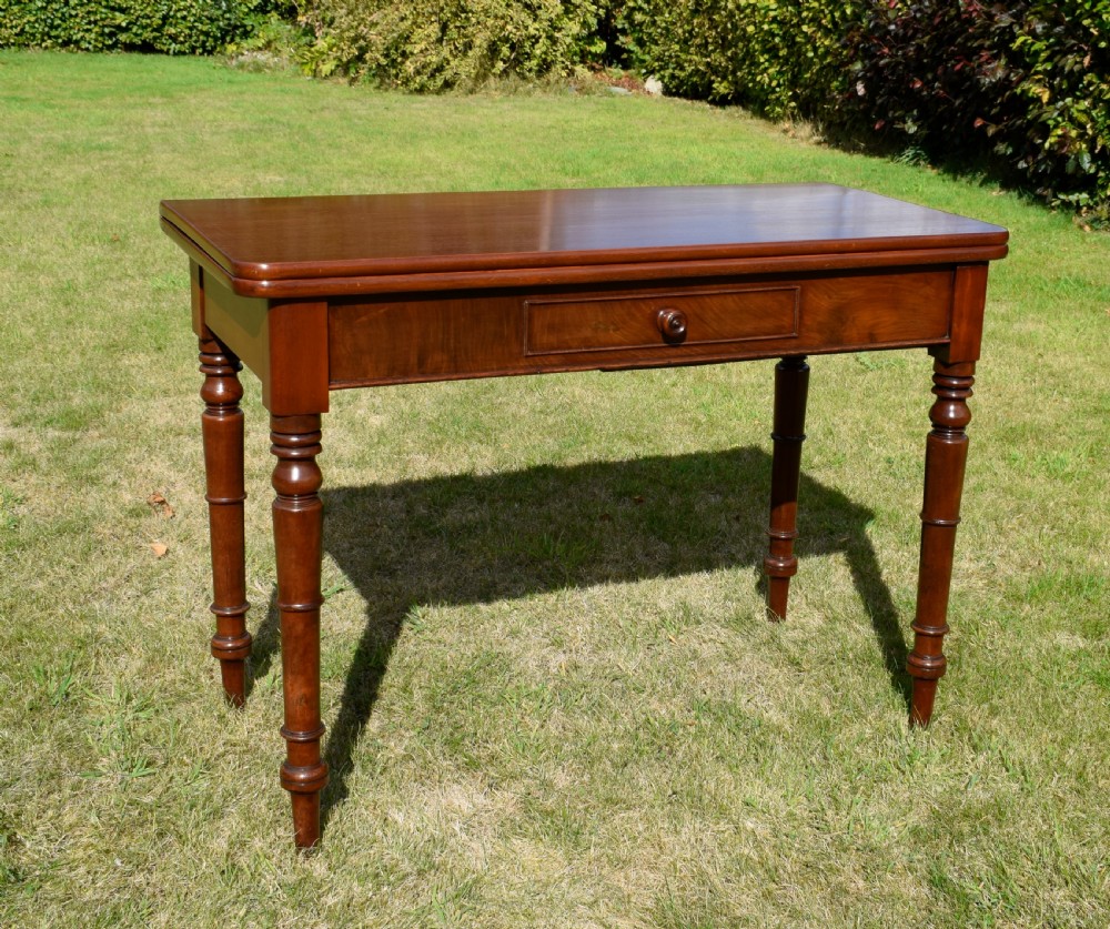 A William IV polished mahogany fold-over games table with turned legs and a single central drawer with a wooden knob. View XV