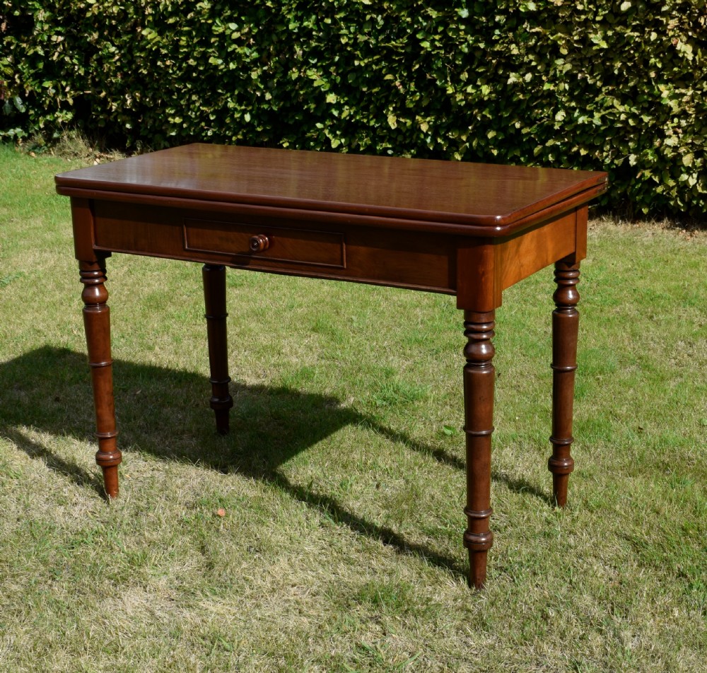 A William IV polished mahogany fold-over games table with turned legs and a single central drawer with a wooden knob. View XVII