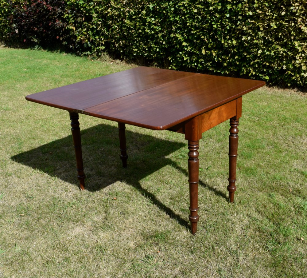 A William IV polished mahogany fold-over games table with turned legs and a single central drawer with a wooden knob. View XX