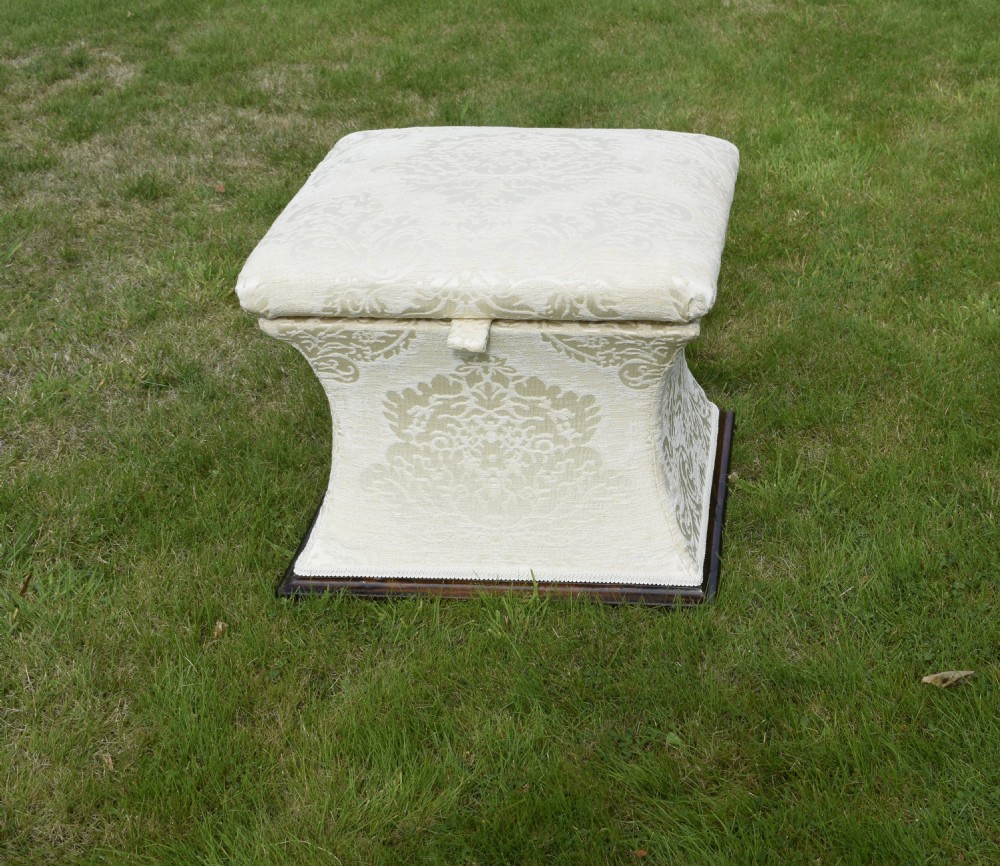 A square Regency storage ottoman with concave sides, upholstered in cream damask fabric and set upon a dark rosewood plinth base. View II