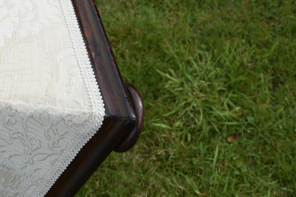 A square Regency storage ottoman with concave sides, upholstered in cream damask fabric and set upon a dark rosewood plinth base. View III