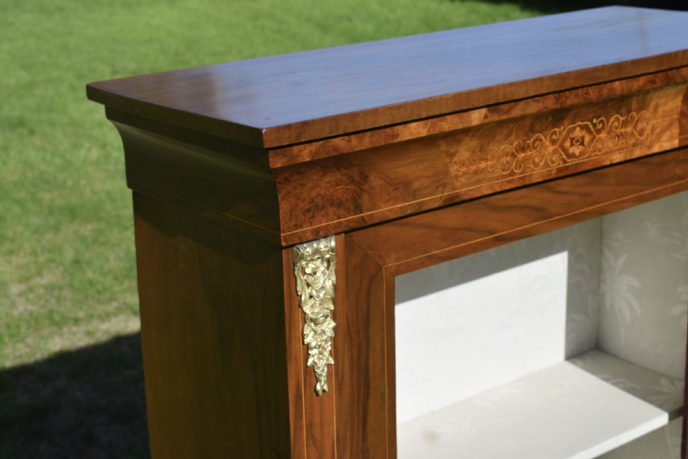 A Victorian warm brown walnut display cabinet featuring a single glazed door, floral wood inlay on the top frieze, and decorative brass mounts. View XIV