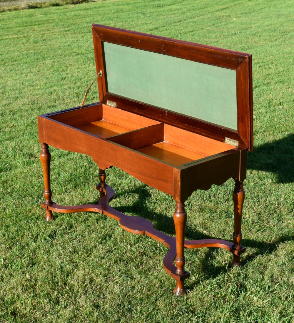 A long mahogany duet stool featuring turned legs, a shaped apron, a central curved cross-stretcher, and a yellow woven upholstered seat. View VI