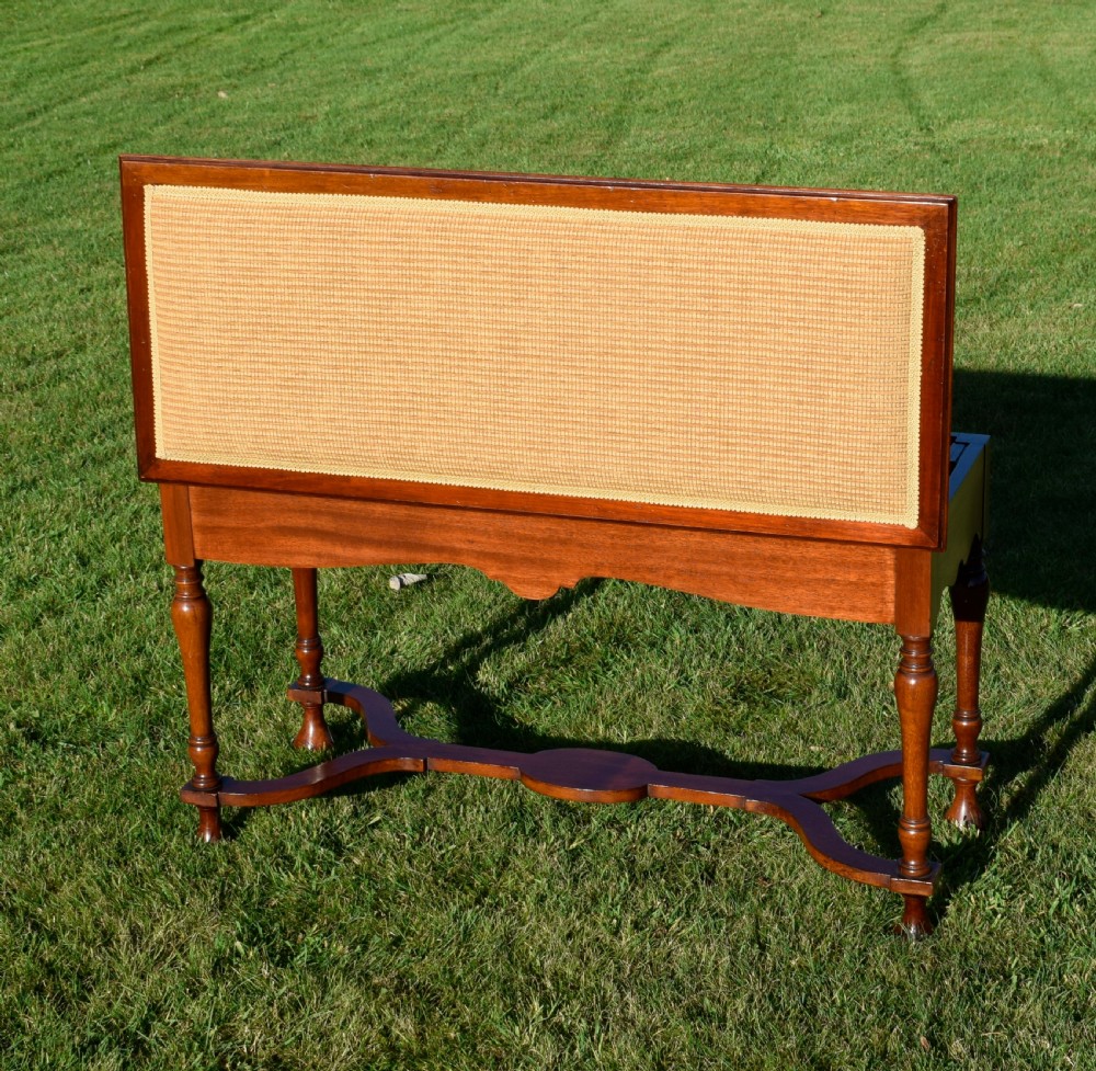 A long mahogany duet stool featuring turned legs, a shaped apron, a central curved cross-stretcher, and a yellow woven upholstered seat. View IX