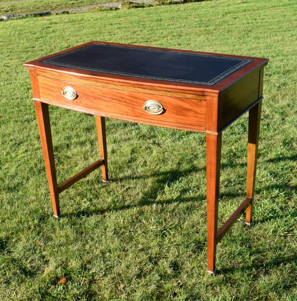 An early twentieth-century mahogany writing table featuring an inset green leather top, a single drawer with two brass oval drop handles, and tapered square legs. View II