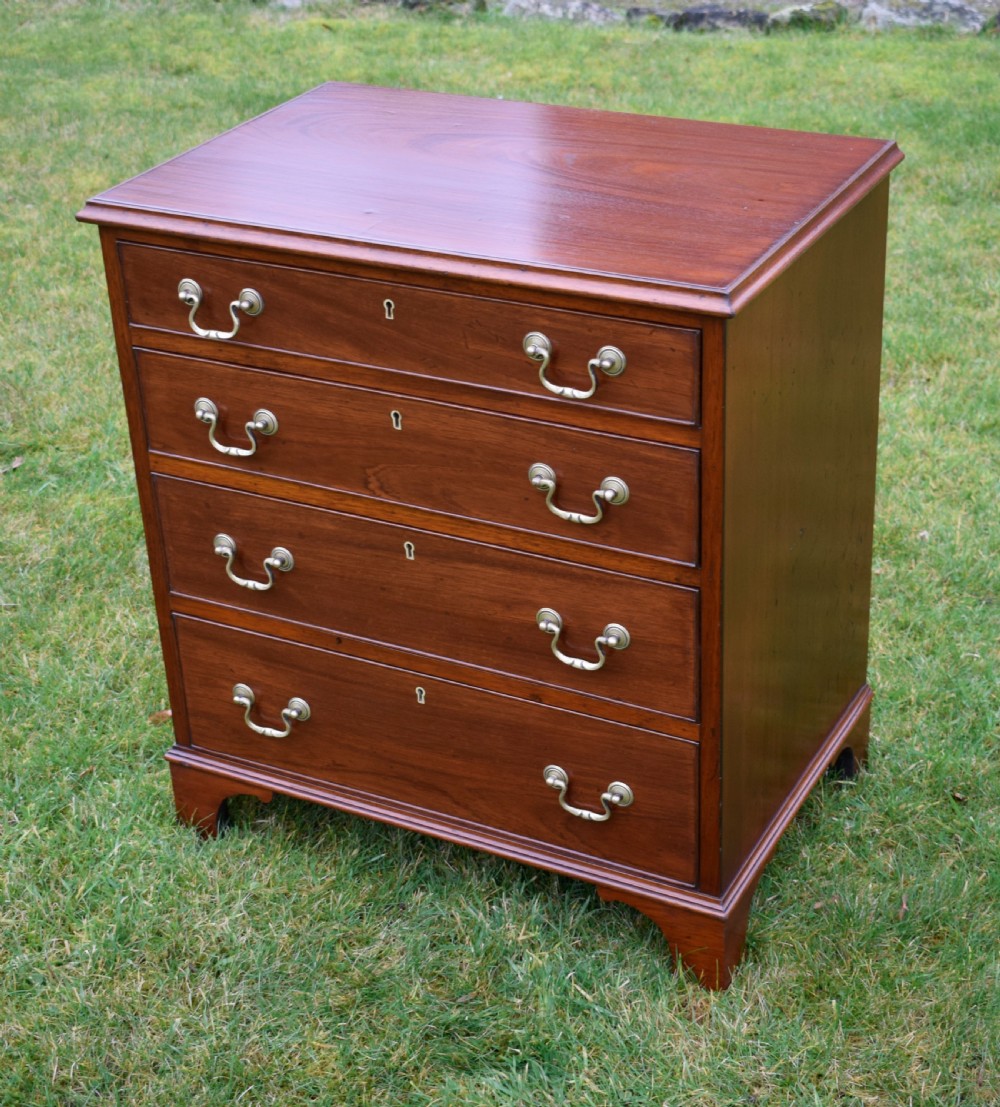 A mahogany chest of drawers featuring four graduated drawers with brass swan-neck handles and bracket feet. View V