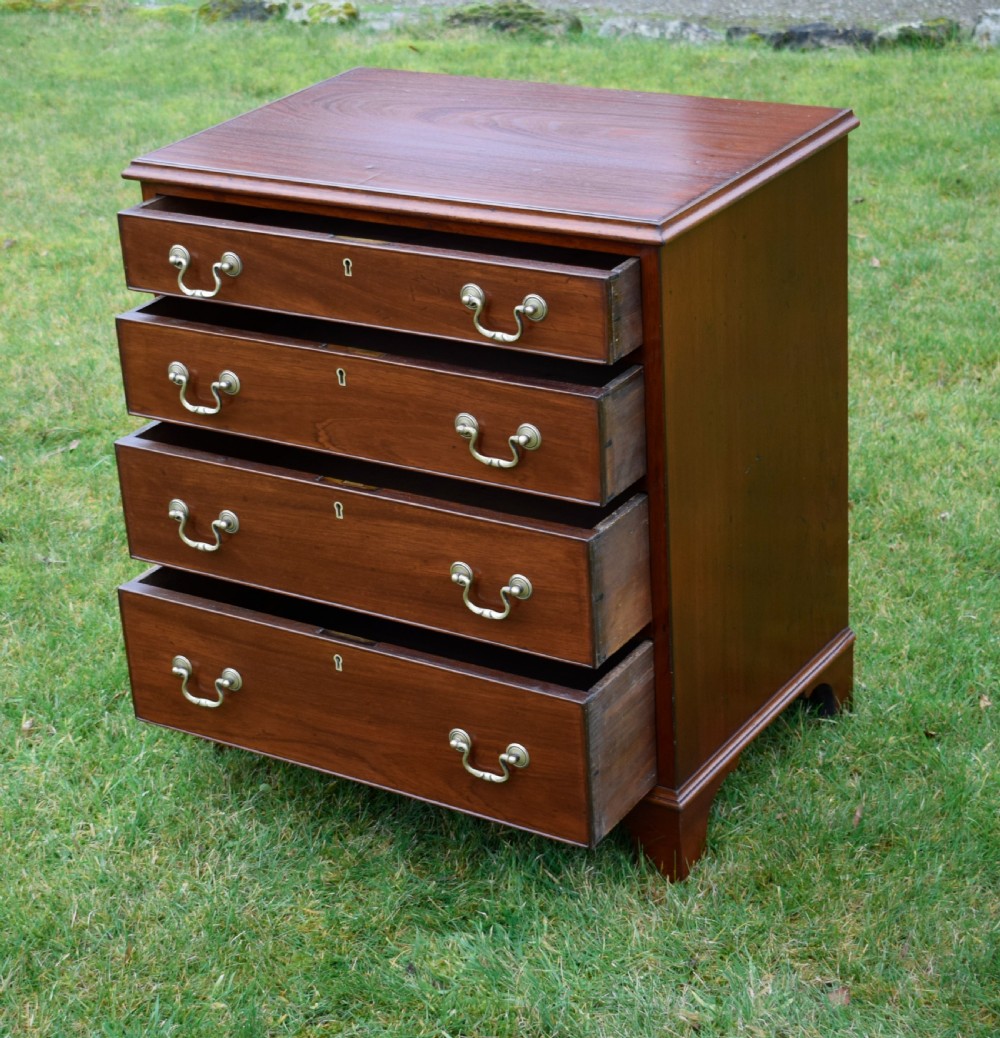 A mahogany chest of drawers featuring four graduated drawers with brass swan-neck handles and bracket feet. View VII